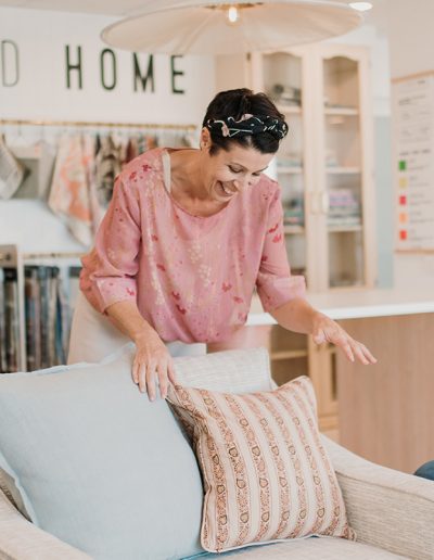 woman arranging cushions on a chair
